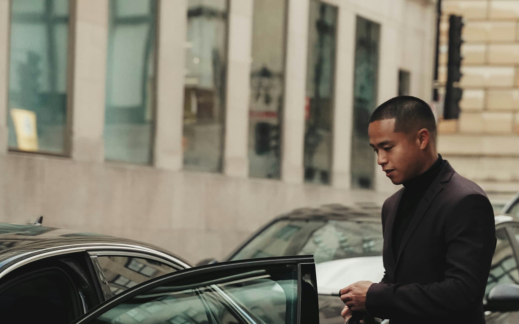 Chauffeur holding the car door open for a guest arriving in London